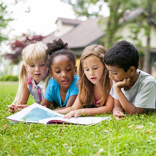 children reading outdoors
